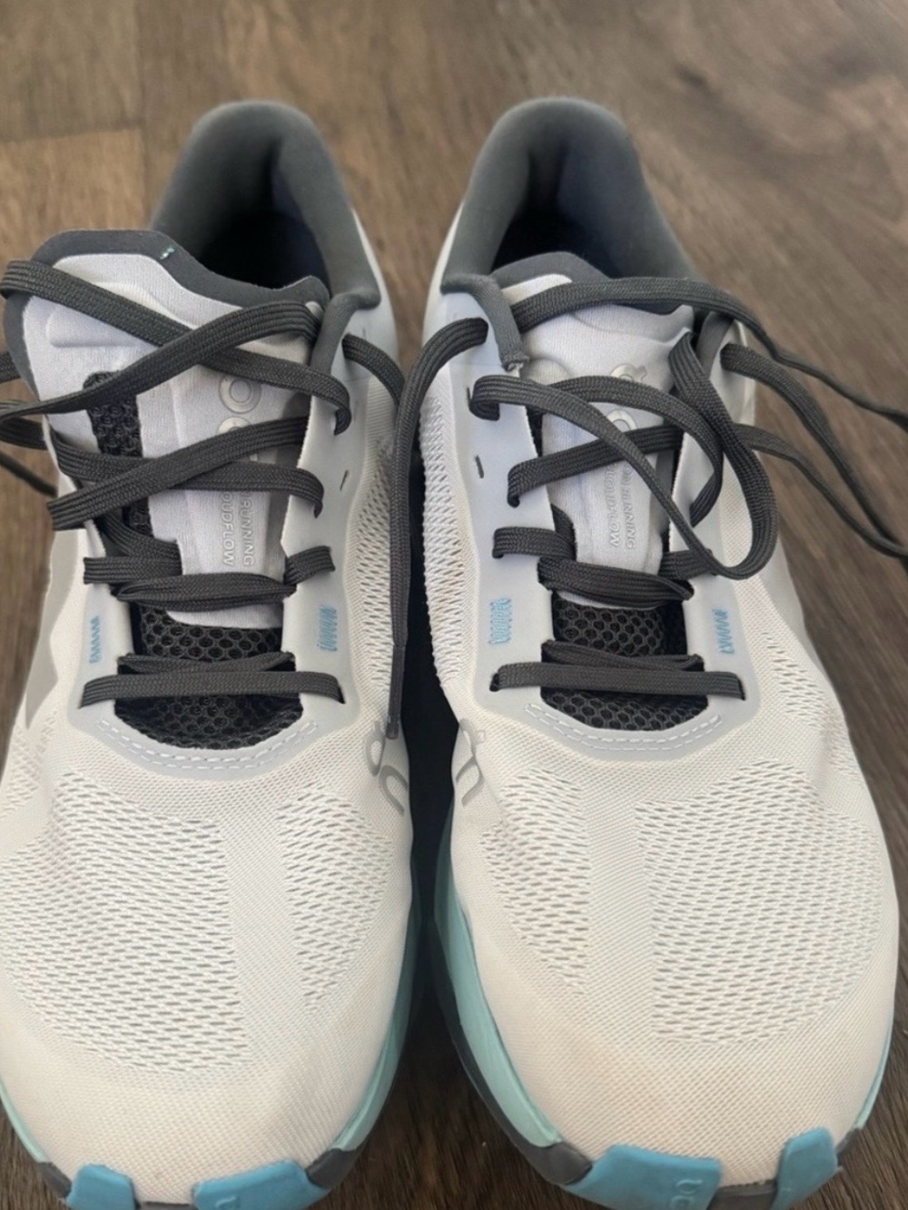 On Running White Athletic Shoes with Light Blue Accents and Gray Laces